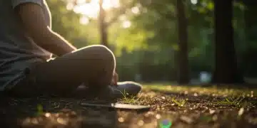 Person meditating outdoors, disconnecting from technology for mental clarity